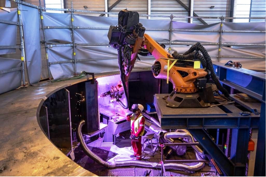 Welding of the segments underway with a robotic arm.jpg