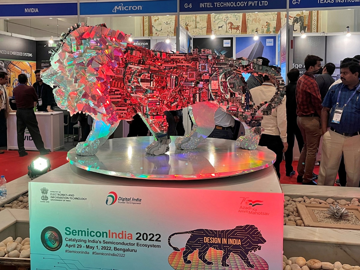 Visitors stand next to a Make In India logo during a three-day semiconductor event in Bengaluru, India, April 30, 2022.