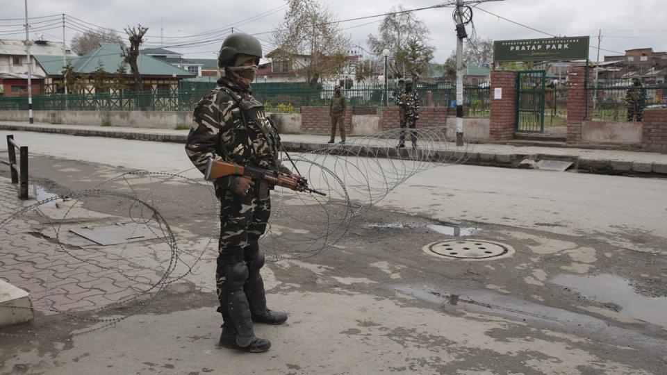 A paramilitary soldier stand guard near a temporary checkpoint during lockdown in Srinagar, India.