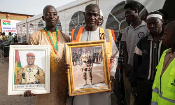 Supporters of Burkina Faso’s President Ibrahim Traore hold photographs of the president at an official donation ceremony to receive Russian wheat in Ouagadougou in January.