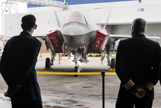 Lockheed Martin dignitaries look over the 100th F-35 fighter after it is introduced in Fort Worth on Dec. 13, 2013.